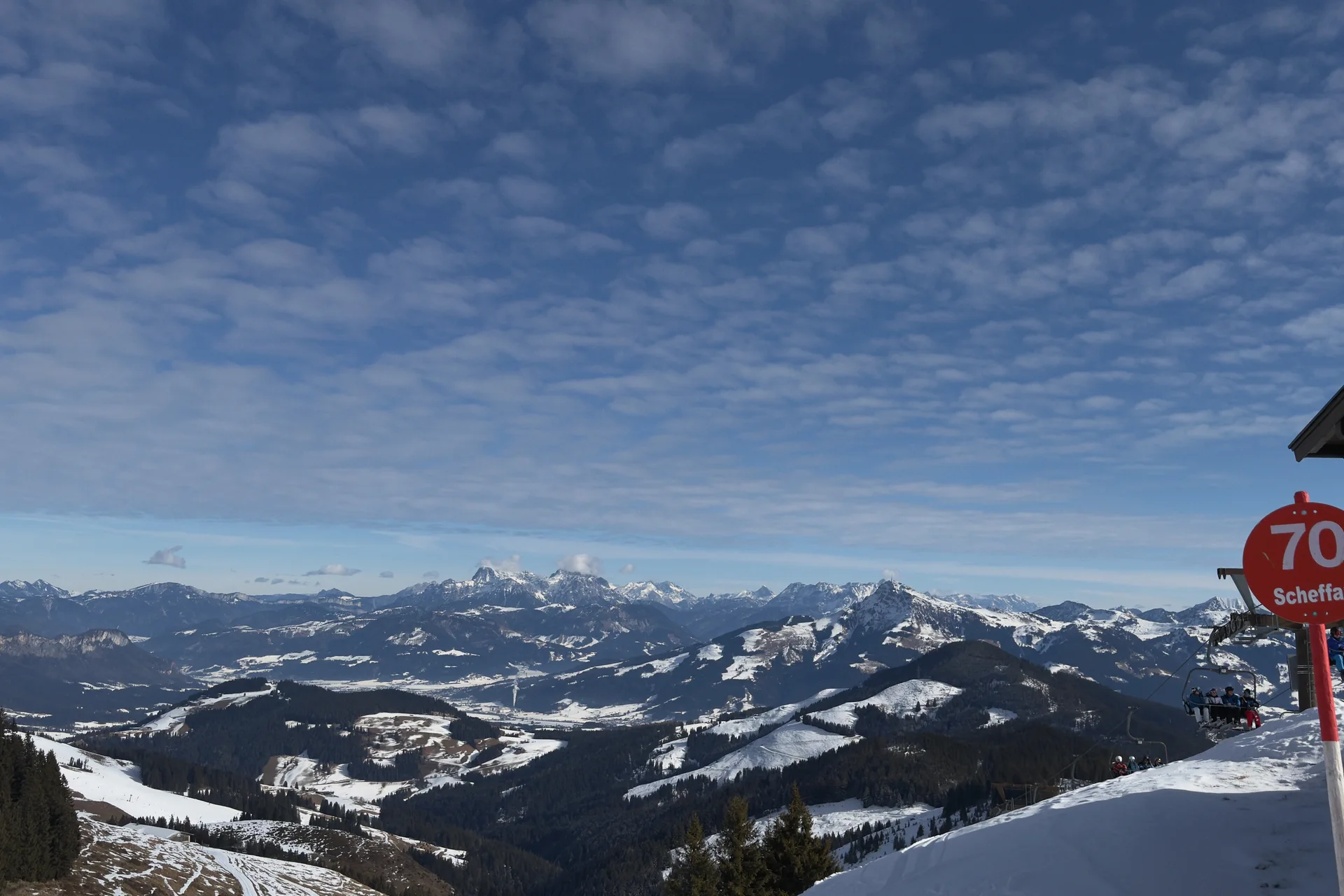 Bergpanorama en besneeuwde pistes bij Scheffau in SkiWelt, met de rode markering van piste 70.